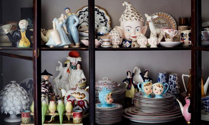 Порцеланови композиции от порцеланови чаши, фигурки и малки вази на рафтове