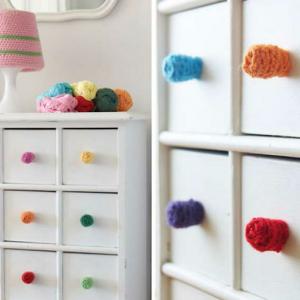 Разноцветни помпони красят белите шкафове