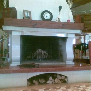 Камина с открито огнище в хотелско фоайе.Облицовка от варовик и мрамор Росо Верона.