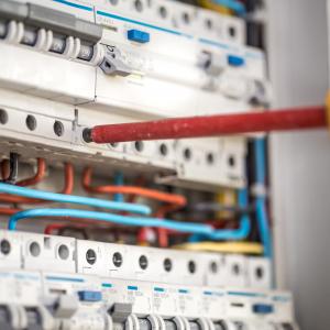 man-electrical-technician-working-switchboard-with-fuses-installation-connection-electrical-equipment-close-up